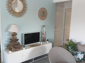 ein Wohnzimmer mit einem Fernseher auf einem weißen Schrank in der Unterkunft Villa 4 étoiles avec piscine, 3 chambres et jardin tropical in Saint-François