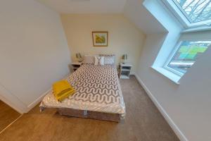 a bedroom with a bed in a room with a window at The Coach House in Westoe