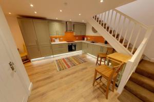 a kitchen with a staircase and a table and chairs at The Coach House in Westoe +6 photos