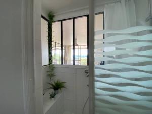 a bathroom with a door and a glass wall at studio/Atelier avec vue sur la Vallée du Cher in Montrichard