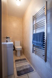 a bathroom with a toilet and a blue towel at Kirsty's Home Near Alton Towers in Rocester