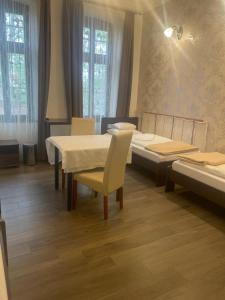 1 dormitorio con mesa, sillas y 1 cama en Kastélykert Fogadó en Szeged