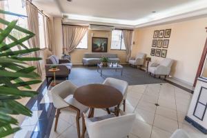 JR Hotel Marilia في ماريليا: غرفة معيشة مع طاولة وكراسي