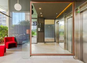 a lobby with a red chair and a glass door at Magnifique Apartament Valencia in Valencia