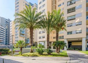 un grupo de palmeras frente a un edificio en Magnifique Apartament Valencia, en Valencia
