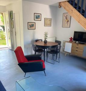 a living room with a table and chairs at Maison piscine Bassin Arcachon in La Teste-de-Buch