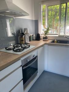a kitchen with a stove top oven next to a sink at Maison piscine Bassin Arcachon in La Teste-de-Buch