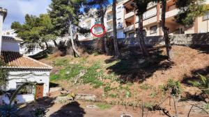 un cartello rosso su una collina accanto a un edificio di Vivienda Minca in La Herradura, Andalusien a La Herradura
