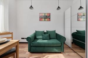 - un canapé vert dans le salon dans l'établissement Norwida Apartment with Balcony Downtown Wrocław by Renters, à Wrocław