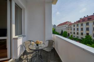 d'un balcon avec une table, des chaises et une fenêtre. dans l'établissement Norwida Apartment with Balcony Downtown Wrocław by Renters, à Wrocław