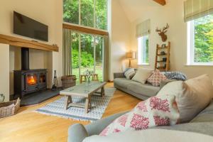 a living room with a couch and a fireplace at Woodland Pytchley in West Runton