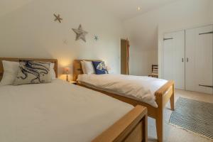 a bedroom with two beds and a star on the wall at Woodland Pytchley in West Runton