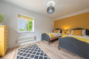 a bedroom with two beds and a window at Castle Bungalow in Thornham