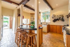 Una cocina con una mesa y taburetes en una habitación. en Estcourt House, en Burnham Market