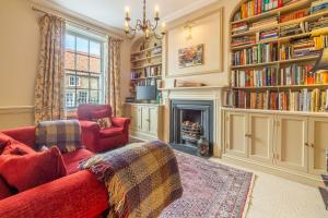 Una sala de estar con un sofá rojo y una chimenea. en Estcourt House, en Burnham Market
