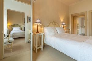 1 dormitorio con 1 cama blanca grande y 2 lámparas. en Estcourt House, en Burnham Market