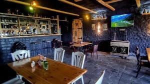 un bar con mesas y sillas y TV en la pared en Green Flower Hotel, en Kutaisi