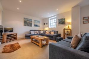 a living room with blue couches and a table at Bluebell Cottage LW in Little Walsingham