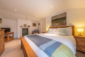 een slaapkamer met een groot bed en een televisie bij Bluebell Cottage LW in Little Walsingham