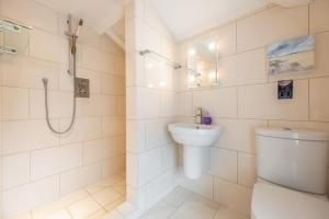 biała łazienka z toaletą i prysznicem w obiekcie Bluebell Cottage LW w mieście Little Walsingham