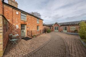 een lege binnenplaats van een bakstenen gebouw bij Bluebell Cottage LW in Little Walsingham