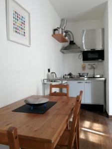 una cucina con tavolo e sedie in legno e una cucina con piano cottura di Al Molo 3 a Como