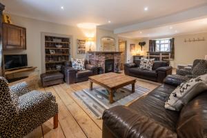 uma sala de estar com mobiliário de couro e uma lareira em The Old Manor House em Brancaster