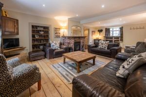 a living room with leather furniture and a fireplace at The Old Manor House in Brancaster