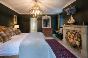 um quarto com uma cama grande e uma lareira em The Old Manor House em Brancaster