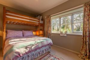 East Rudham的住宿－Garden Cottage ER，一间卧室设有一张床和两个窗户。