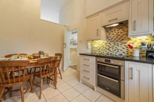 a kitchen with a table and a dining room at The Saltings Blakeney in Blakeney