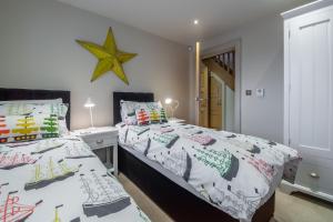 a bedroom with two beds and a star on the wall at Tucked Away Cottage in Langham