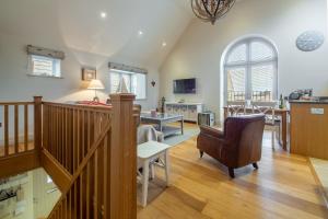 a large living room with a staircase and a living room at Tucked Away Cottage in Langham