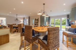 una cucina e una sala da pranzo con tavolo e sedie in legno di Waterside a Wiveton