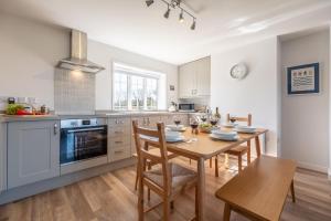 uma cozinha com uma mesa de madeira e uma sala de jantar em Twitchers Cottage em Titchwell