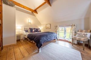 a bedroom with a bed and a window at Cornloft Cottage in South Creake