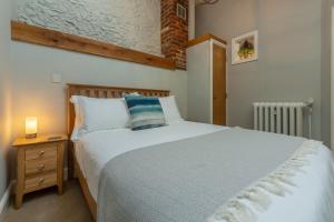 a bedroom with a large white bed and a night stand at The Old Chapel W in Little Walsingham