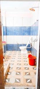 ein Badezimmer mit einem WC und einem blauen und weißen Fliesenboden in der Unterkunft OYO Dream Guest House in Rāmpura