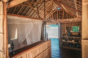 einen Innenblick auf ein Zimmer in einem Holzhaus in der Unterkunft Methos Homestay - Raja Ampat in Yennanas Besir