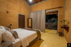 a bedroom with a bed and a sliding glass door at Anura's Elephant in Beruwala