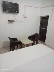 Cette chambre dispose d'une table, de chaises et d'une télévision. dans l'établissement OYO Hotel Sky View 1, à Moradabad