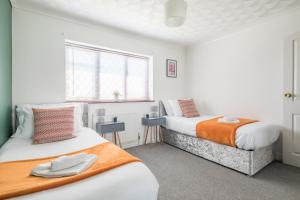 a bedroom with two beds and a window at Foxdale's - 5 Bedroom House in Peterborough perfect for groups and families in Peterborough