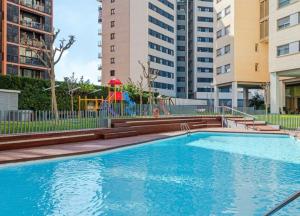 uma piscina com parque infantil e alguns edifícios em Magnifique Apartament Valencia em Valência