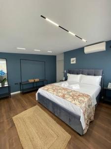 um quarto com uma cama grande e uma parede azul em Voyage Penthouse em Tirana