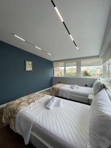 um quarto com 2 camas e uma grande janela em Voyage Penthouse em Tirana