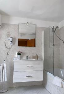 een badkamer met een wastafel, een bad en een spiegel bij I Limoni del Sud Sardegna in Assemini