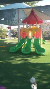 a playground with a slide in a park with a dog at LTD Hadas Garden apartment in Tiberias