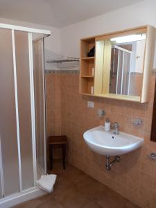 a bathroom with a sink and a shower with a mirror at AFFITTACAMERE DORGALI B&B da ZIETTO in Dorgali