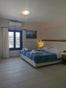 - une chambre avec un grand lit et une fenêtre dans l'établissement Argalios Studios, à Kiónion