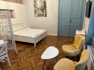 Cette petite chambre comprend un lit et deux chaises. dans l'établissement VISAJ Deluxe Downtown, à Timişoara